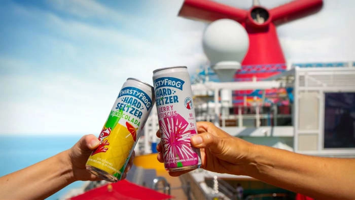 Two people hold up Carnival's hard seltzer cans. ThirstyFrog Seltzer Lead JS 100722