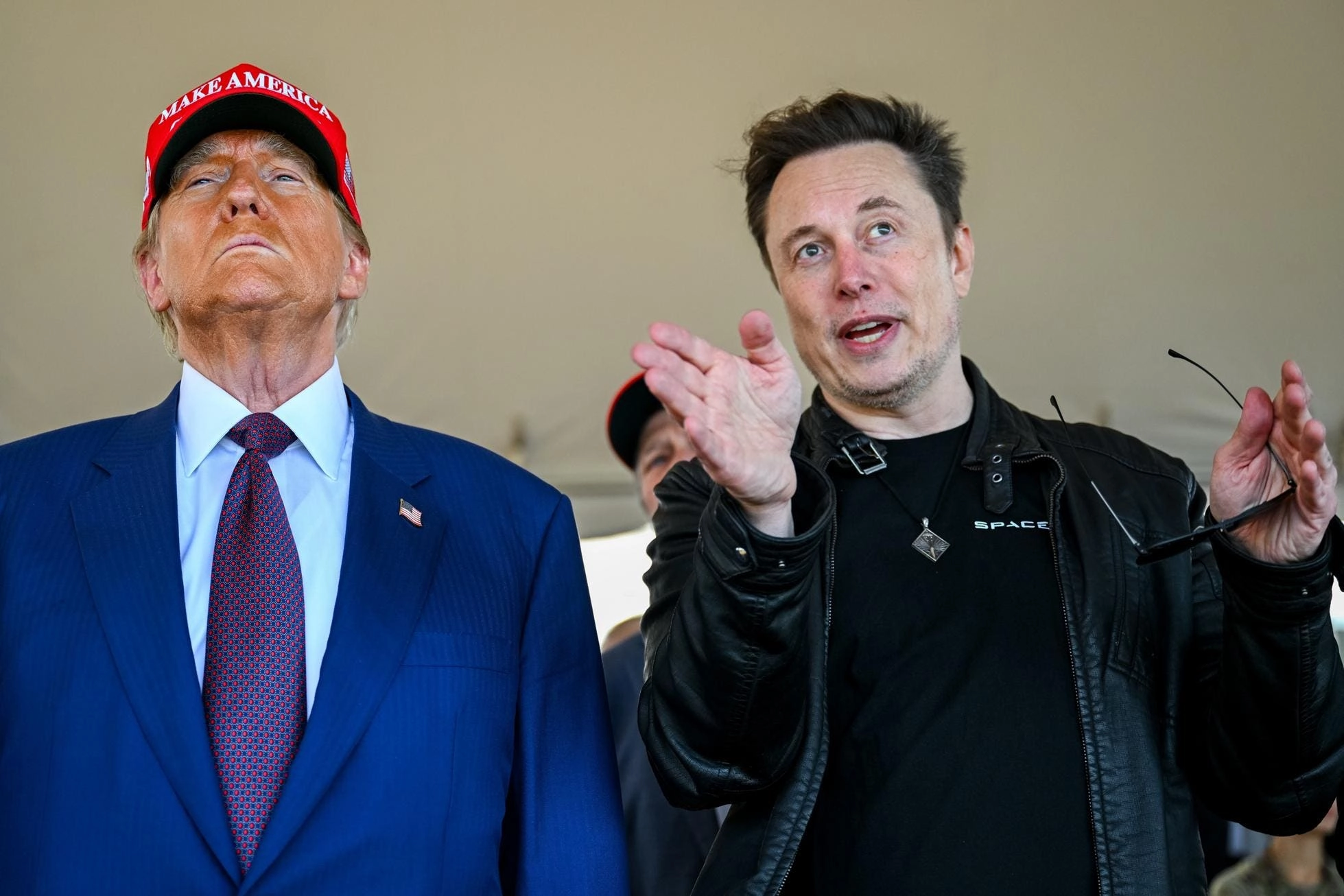 Elon Musk speaks with U.S. President-elect Donald Trump as they watch the launch of the sixth test flight of the SpaceX Starship rocket.