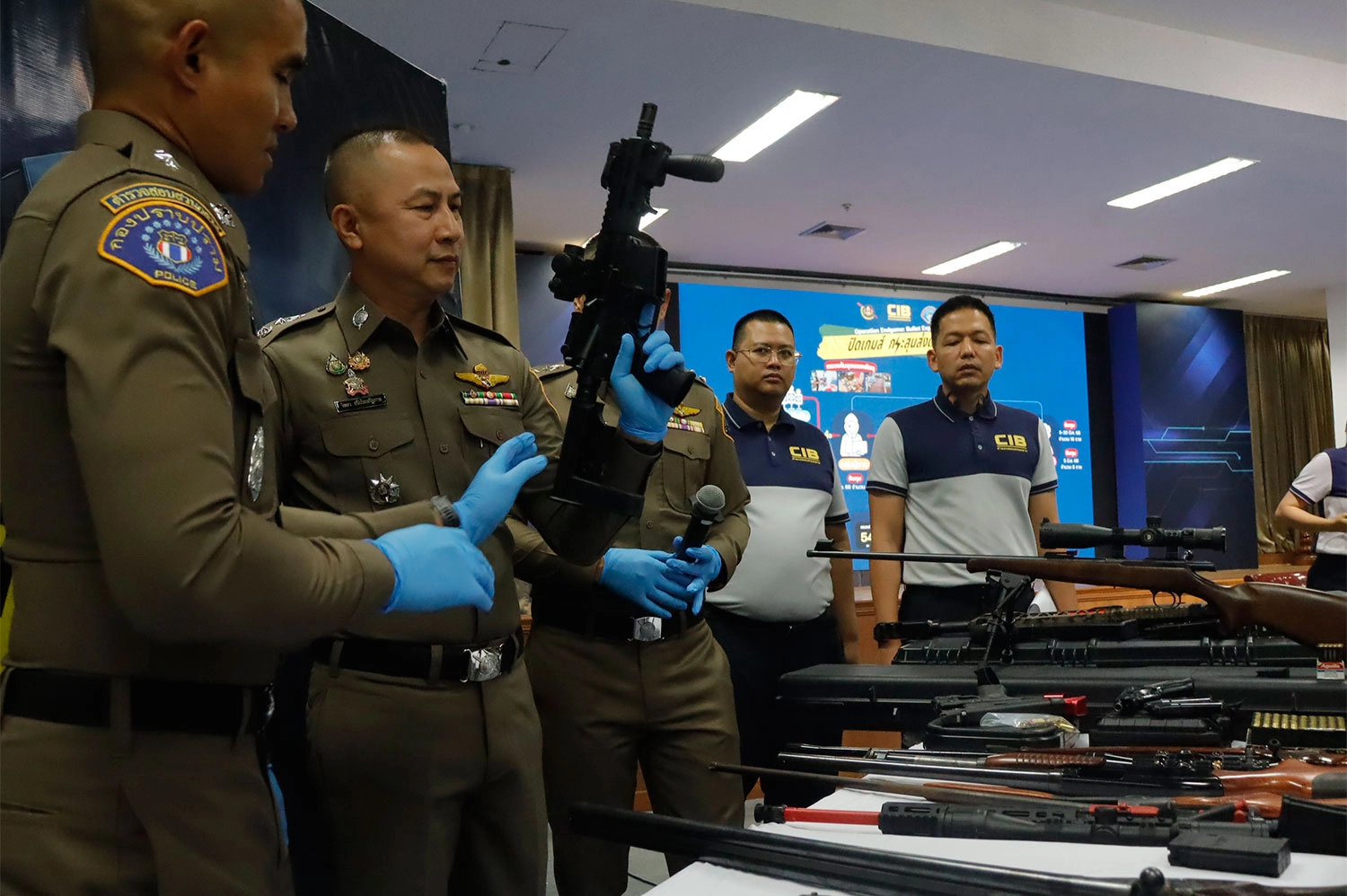 Pol Maj Gen Wittaya Sriprasertparb, head of the Crime Suppression Division, inspects a seized weapon during a briefing on Tuesday in Bangkok. (Photo supplied/Wassayos Ngamkham)