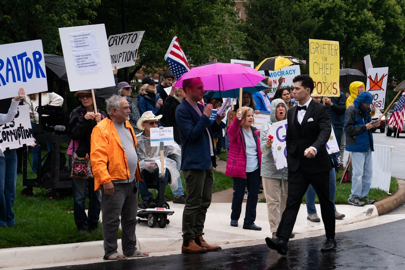 A photo of a guest at Trumps May 22 memecoin donor dinner in suburban Virginia walking past protesters.