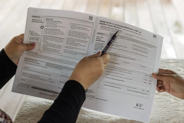 Children's Defense Fund Program Director Graciela Camarena assists Lucia Salazar with filling out Medicaid and SNAP application forms for her family in Pharr, Texas, Nov. 13, 2023. (AP Photo/Michael Gonzalez, File)