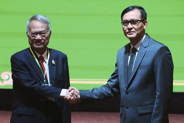 Cambodian Minister in charge of State Secretariat of Border Affairs Lam Chea, right, shakes hands with Thai Border Affairs Advisor to the Ministry of Foreign Affairs Prasas Prasasvinitchai, left, during a meeting of the Cambodian-Thai joint commission on demarcation for land boundary in Phnom Penh, Cambodia, Saturday, June 14, 2025. (AP Photo/Heng Sinith, file)