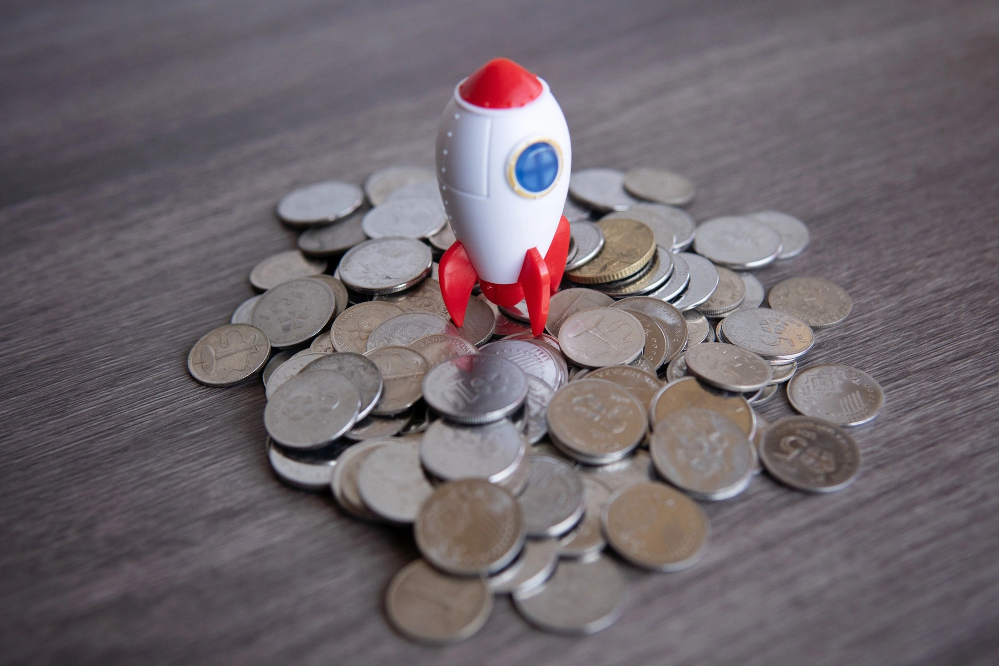 Closeup image of rocket spaceship and coins.