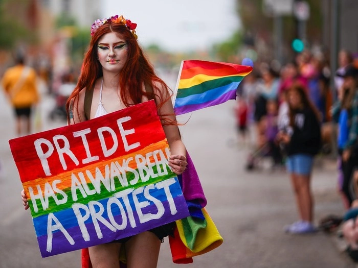 A person holds a sign that says 