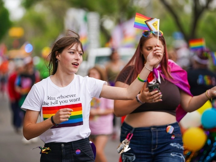 A person holds a pride flag during the Queen City Pride Parade