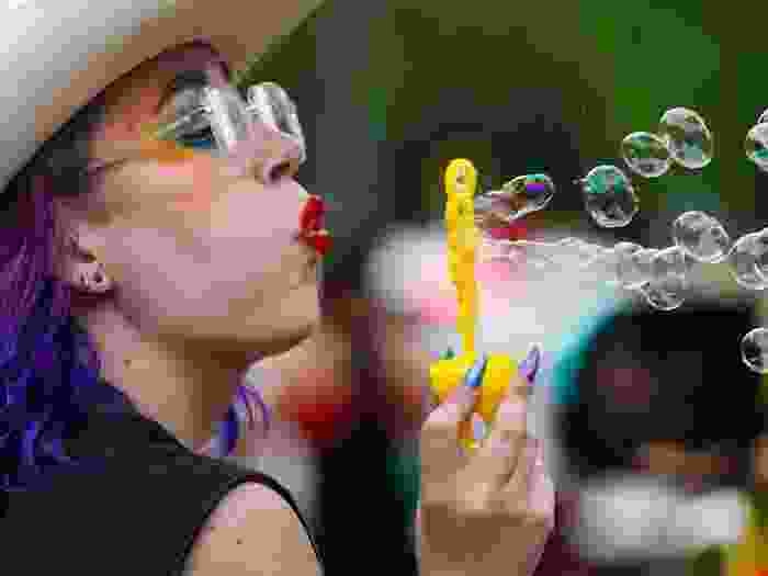 A person blows bubbles during the Queen City Pride Parade