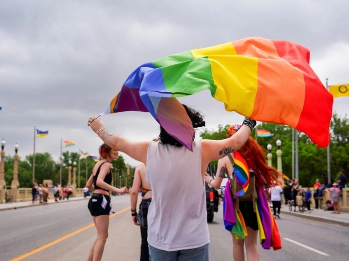 A person waves a pride flag during the pride parade