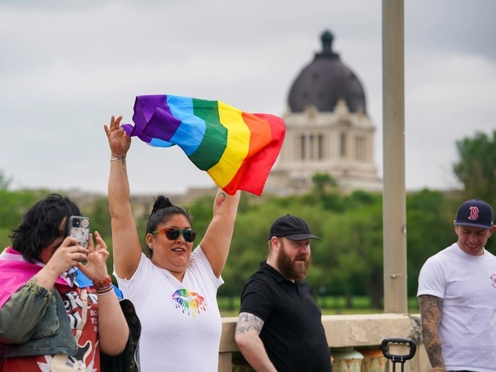 A spectator holds a pride flag during the Queen City Pride Parade