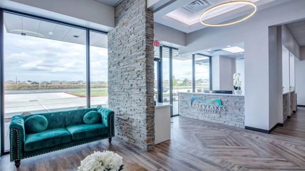 A reception area with a green couch and a stone wall AI-generated content may be incorrect.