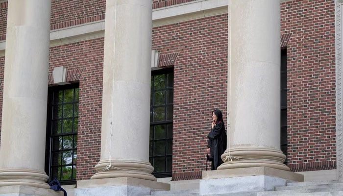 Harvard College graduate, Iris Lang of Florida watches a photo session on the Harvard University campus in Cambridge, Massachusetts, US, May 23, 2025.  Reuters