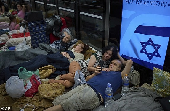 People take shelter in an underground metro station as a precaution against possible Iran missile attacks, in Ramat Gan, near Tel Aviv, Israel, Tuesday, June 17, 2025. (AP Photo/Oded Balilty)