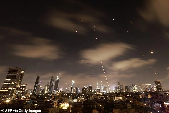 Israeli air defence systems are activated to intercept Iranian missiles over the Israeli city of Tel Aviv early on June 18, 2025. Israel and Iran exchanged fire again on June 17, the fifth day of strikes in their most intense confrontation in history, fuelling fears of a drawn-out conflict that could engulf the Middle East. (Photo by Menahem Kahana / AFP) (Photo by MENAHEM KAHANA/AFP via Getty Images)