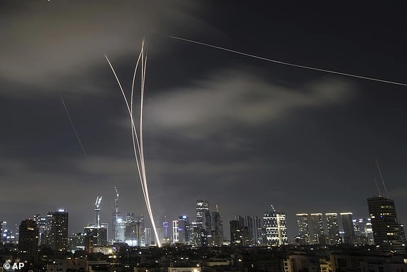 The Israeli air defense system fires to intercept missiles during an Iranian attack over Tel Aviv, Israel, early Wednesday, June 18, 2025. (AP Photo/Leo Correa)