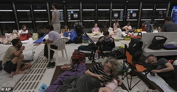 People take shelter in an underground metro station in prevention of Iran missile attacks, in Ramat Gan, near Tel Aviv, Israel, Tuesday, June 17, 2025. (AP Photo/Oded Balilty)