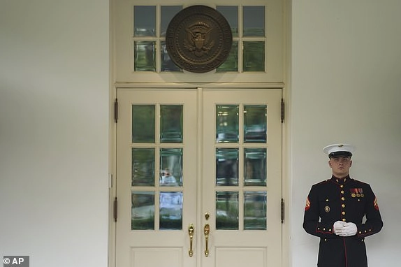 A U.S. Marine stands outside the entrance to the West Wing of the White House as President Donald Trump meets in the Situation Room, Tuesday, June 17, 2025, in Washington. (AP Photo/Evan Vucci)