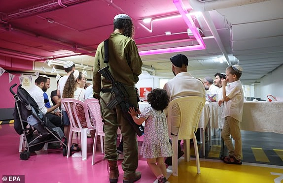 epa12181768 People sing songs after eating dinner at an underground parking lot amid ongoing Iranian ballistic missile attack threats across the country, in Tel Aviv, Israel, 17 June 2025. Israel's military announced that sirens sounded in various regions across the country after missiles were launched from Iran towards Israel. EPA/ABIR SULTAN