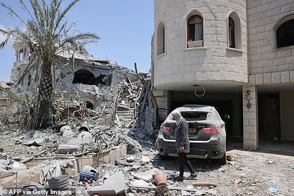 A woman checks the destruction in the northern Arab-Israeli city of Tamra, on June 17, 2025. An Iranian missile killed four people in the city of Tamra on June 14: Manar al-Qassem Abu al-Hija Khatib (39), her two daughters Hala (13) and Shada (20), and their relative Manar Diab Khatib (41). Dozens more were wounded. (Photo by AHMAD GHARABLI / AFP) (Photo by AHMAD GHARABLI/AFP via Getty Images)