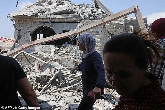 Women react as they check the destruction in the northern Arab-Israeli city of Tamra, on June 17, 2025. An Iranian missile killed four people in the city of Tamra on June 14: Manar al-Qassem Abu al-Hija Khatib (39), her two daughters Hala (13) and Shada (20), and their relative Manar Diab Khatib (41). Dozens more were wounded. (Photo by AHMAD GHARABLI / AFP) (Photo by AHMAD GHARABLI/AFP via Getty Images)