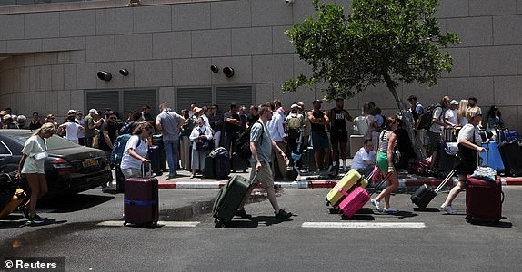 People with foreign nationalities gather to leave Israel on buses via Egypt, following a missile attack from Iran, in Tel Aviv, Israel, June 17, 2025. REUTERS/Ronen Zvulun