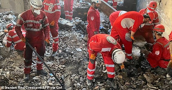 This handout picture released by the Iranian Red Crescent on June 17, 2025 shows members of their rescue teams searching the debris inside a buidling in Tehran, targeted by Israeli strikes. Israel and Iran exchanged missile fire for a fifth consecutive day on June 17, with the Israeli military saying in a statement it targeted multiple missile and drone sites in west Iran, including infrastructure, launchers and storage facilities. (Photo by Iranian Red Crescent / AFP) / === RESTRICTED TO EDITORIAL USE - MANDATORY CREDIT 