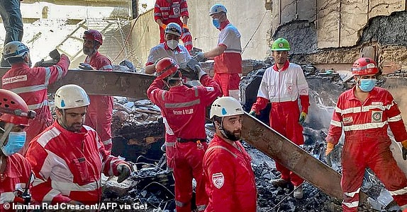This handout picture released by the Iranian Red Crescent on June 17, 2025 shows members of their rescue teams searching the debris inside a buidling in Tehran, targeted by Israeli strikes. Israel and Iran exchanged missile fire for a fifth consecutive day on June 17, with the Israeli military saying in a statement it targeted multiple missile and drone sites in west Iran, including infrastructure, launchers and storage facilities. (Photo by Iranian Red Crescent / AFP) / === RESTRICTED TO EDITORIAL USE - MANDATORY CREDIT 