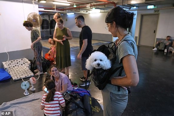 Israelis get ready to take shelter in a parking garage in prevention of a missile attack from Iran, in Tel Aviv, Israel, Monday, June 16, 2025. (AP Photo/Baz Ratner)