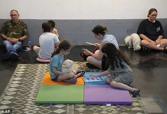 Israelis take shelter in a parking garage during a missile alert from Iran, in Tel Aviv, Israel, early Tuesday, June 17, 2025. (AP Photo/Baz Ratner)