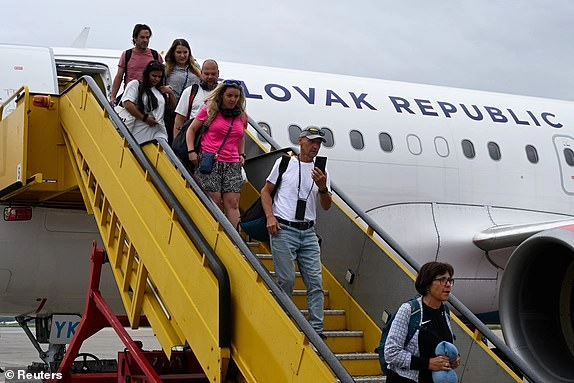 Repatriated Slovaks, along with Czechs, Austrians and Slovenians, returning from Israel, disembark from a flight from Amman, after they left the region following a missile attack from Iran on Israel, at M. R. Stefanik Airport, in Bratislava, Slovakia, June 16, 2025. REUTERS/Radovan Stoklasa