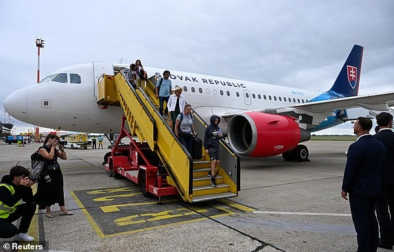 Repatriated Slovaks, along with Czechs, Austrians and Slovenians, returning from Israel, disembark from a flight from Amman, after they left the region following a missile attack from Iran on Israel, at M. R. Stefanik Airport, in Bratislava, Slovakia, June 16, 2025. REUTERS/Radovan Stoklasa