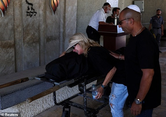 A woman reacts at the funeral of Bella Ashkenazi, who was killed at her home when a missile fired from Iran hit it, in Holon, Israel June 16, 2025. REUTERS/Ronen Zvulun
