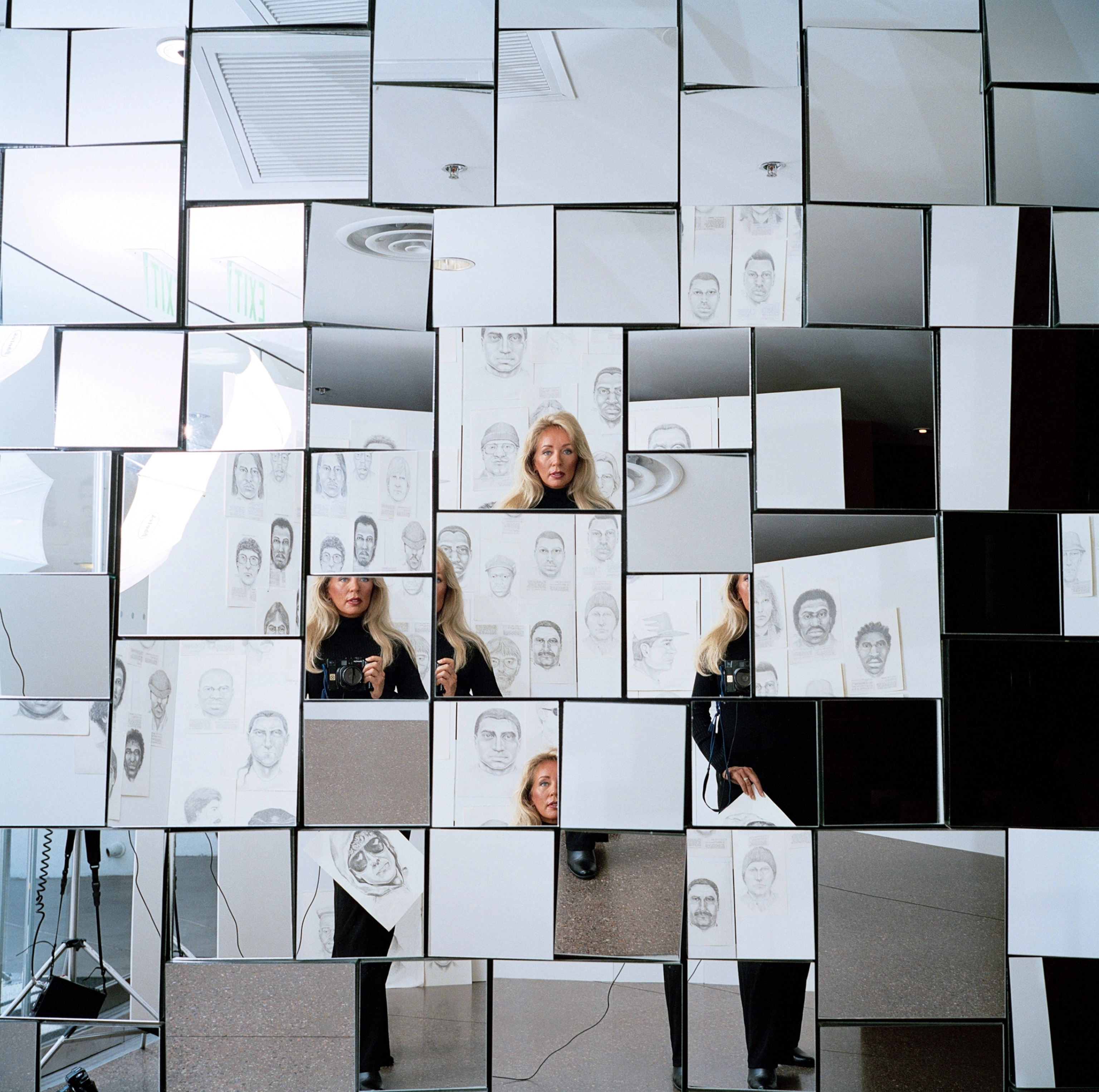 There are square mirrors in different shapes and sizes. In some of them there is a woman's face. In others there are sketches of faces.