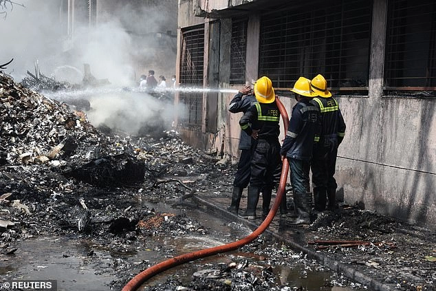 Firefighters work to put out a fire at the site where an Air India Boeing 787 Dreamliner plane crashed in Ahmedabad, India, June 12, 2025