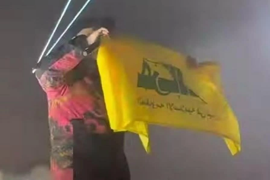 Mo Chara holds up a flag allegedly in support of Hizbollah at a concert in Kentish Town, London in 2024