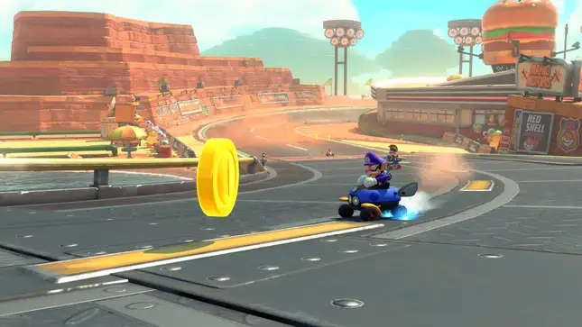 Waluigi drifts towards a coin ahead of other drivers.
