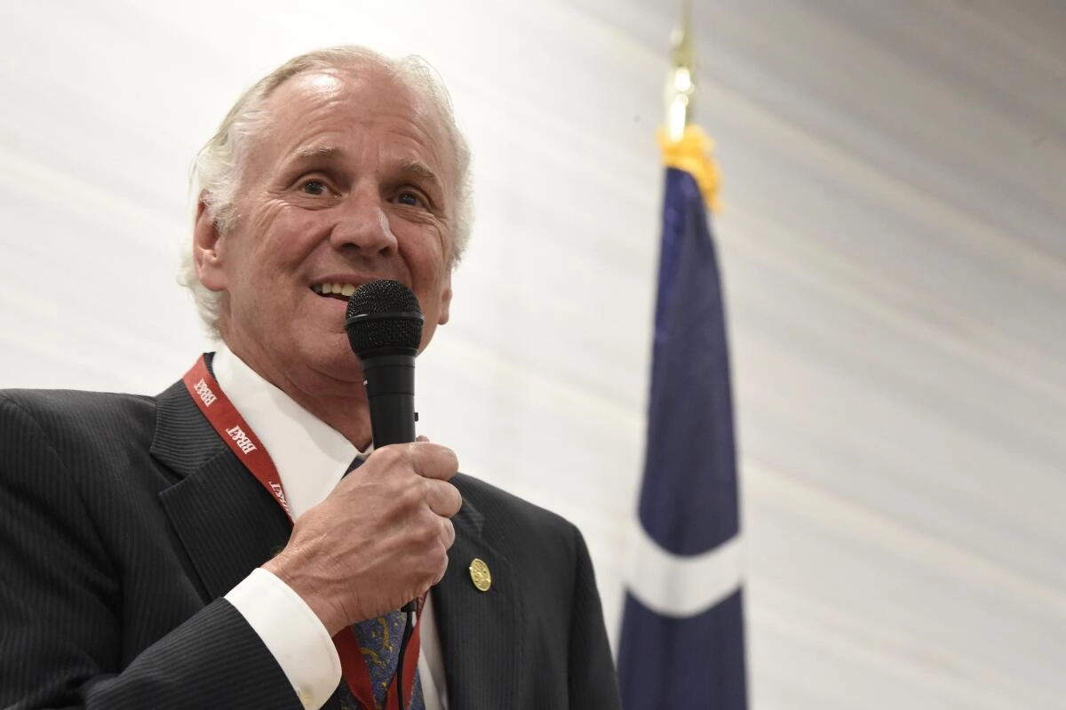 Former South Carolina Gov. Henry McMaster speaks into a handheld microphone.