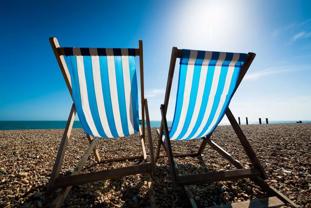Two deck chairs on a beach