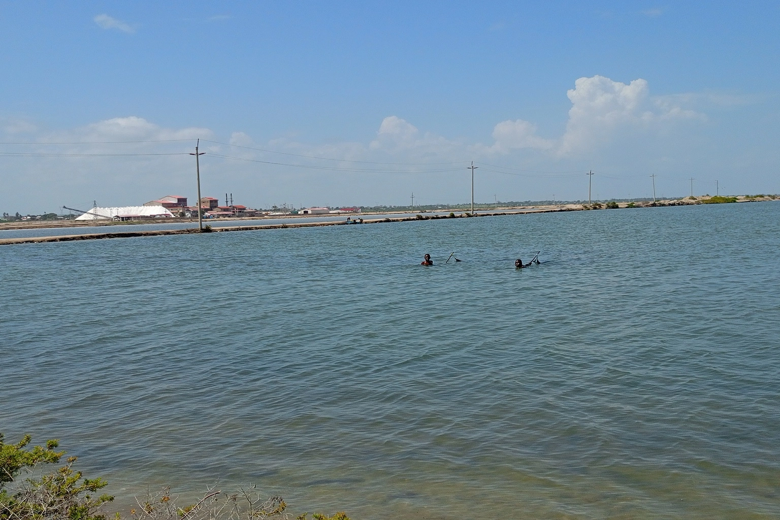 Two young men fish in a salt pan operated by Malindi Salt Works Limited.