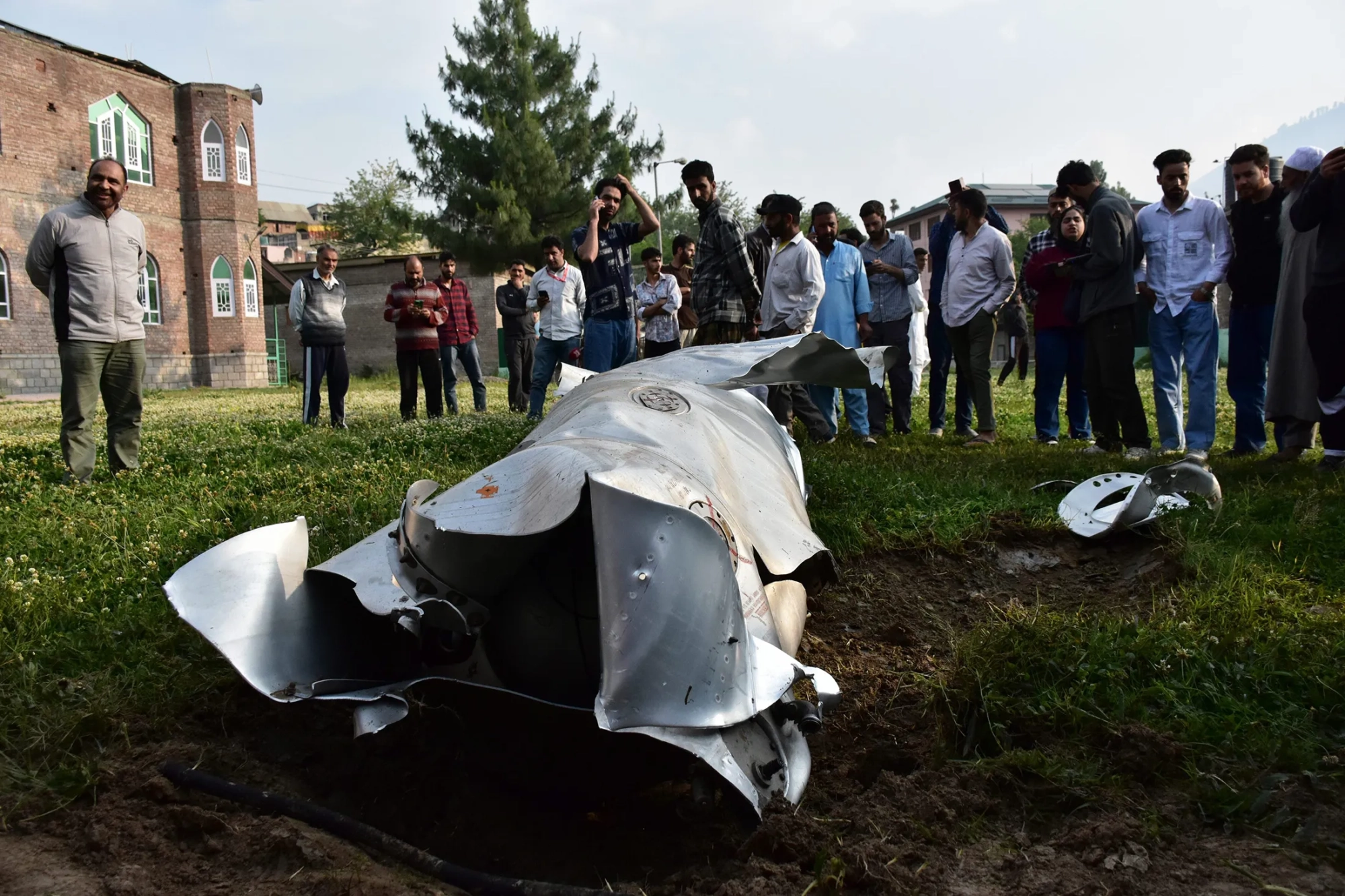 Residents look at a wreckage of an unknown aircraft in Wuyan