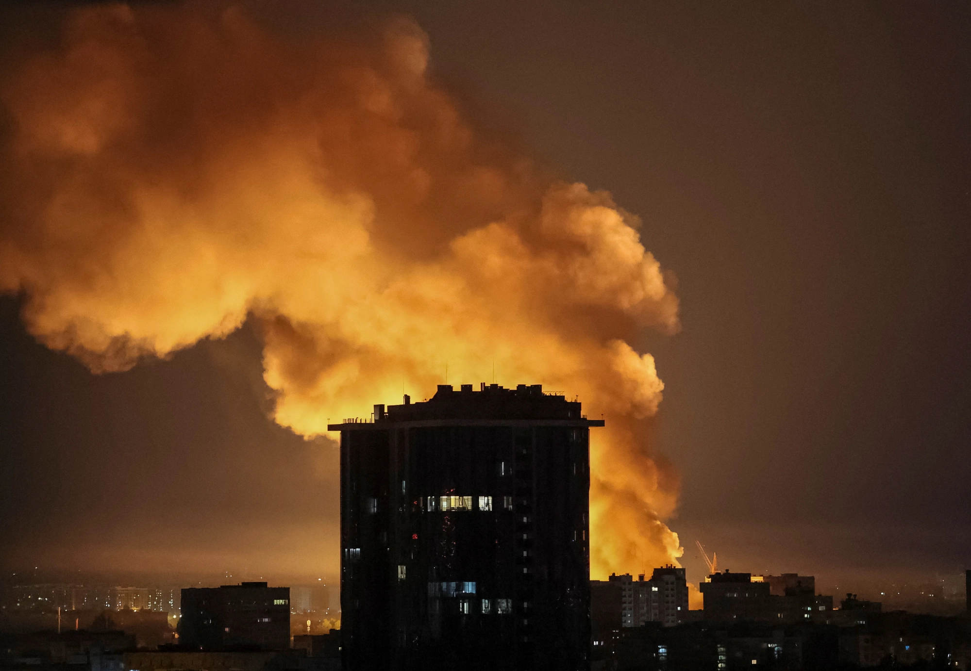 Explosion near a city building at night.
