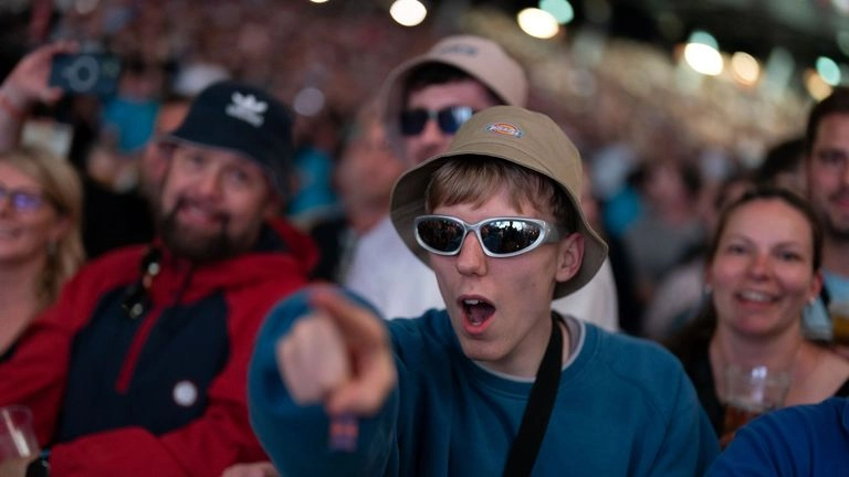 An Oasis fan is pointing at the stage during the gig. Pic: PA
