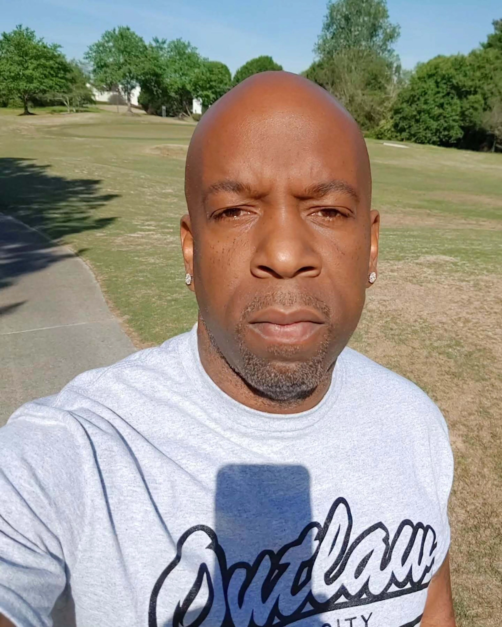 Man wearing a gray shirt with Outlaw City on it.