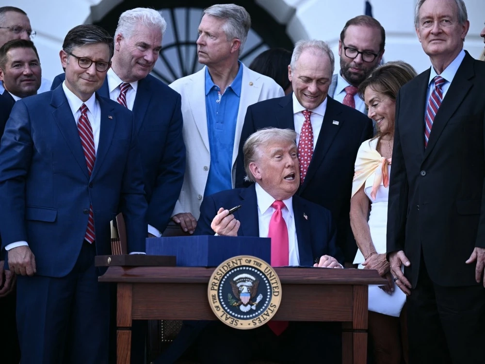 U.S. President Donald Trump (centre) prepares to sign the