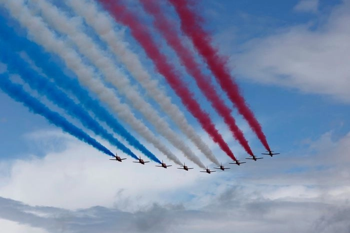 The Red Arrows fly over the grid.