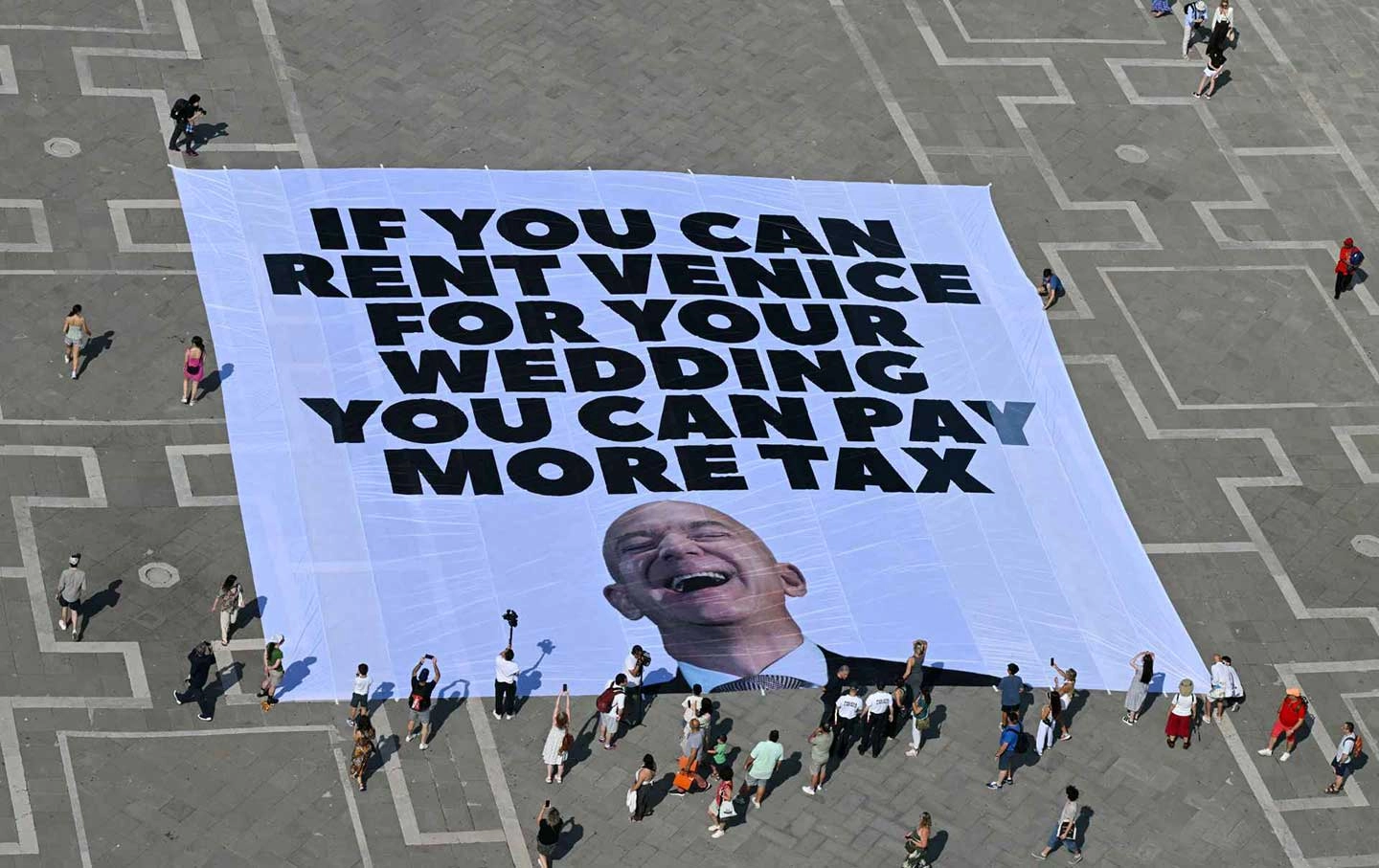 Greenpeace activists deploy a giant banner at St. Marks Square in Venice on June 23, 2025.