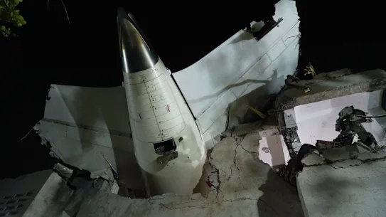 The tail of the Air India plane is seen stuck in a building at the site of the crash in Indias northwestern city of Ahmedabad in Gujarat state.