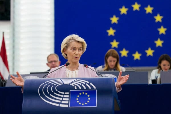 Ursula von der Leyen speaking at a lectern with the European Union flag behind her.
