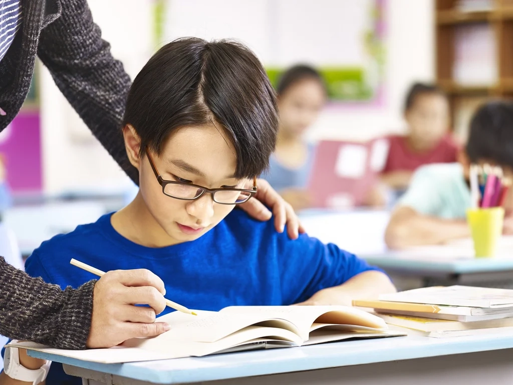 A pupil gets help from teacher in class. One of the most forceful condemnations of the proposed drama came from South Koreas largest teaching union. Photo: Shutterstock