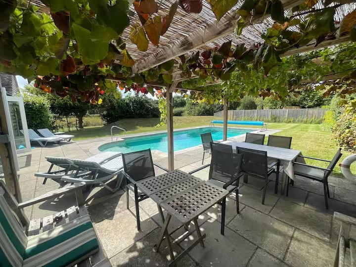 Patio with pool and seating area.