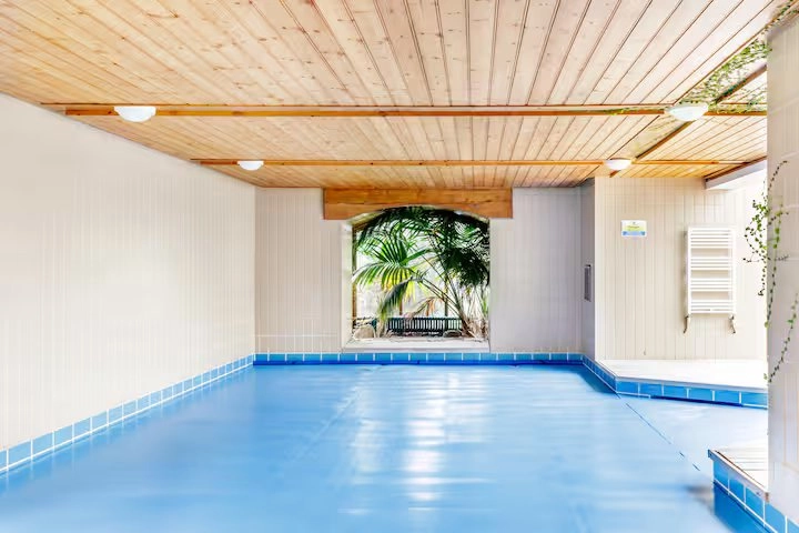 Converted granary pool area with light blue floor and wood ceiling.