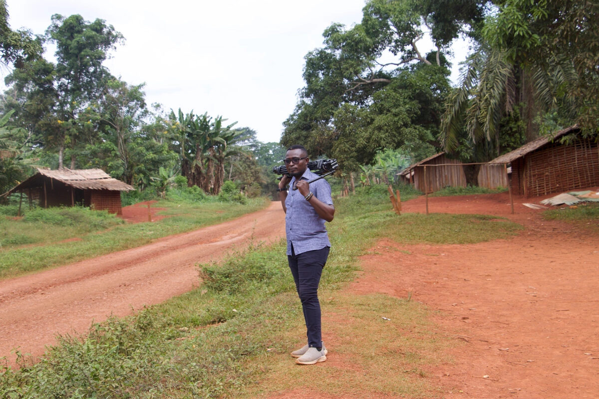 David Akana carrying a tripod after filming members of the Baka community demonstrating the use of Sapelli technology to monitor parts of the forest in southeastern Cameroon, during a recent reporting trip to Lob�k� National Park. Photo by Yanick Kenne